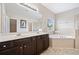 Bathroom featuring double sink vanity, a soaking tub, and a shower with glass door at 4920 Fourth Rail Ln, Cumming, GA 30040