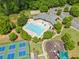 An aerial view displaying a community pool, clubhouse, playground, and tennis courts surrounded by lush landscaping at 4920 Fourth Rail Ln, Cumming, GA 30040
