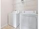 Neat laundry room with white washer and dryer units and wire shelving at 4920 Fourth Rail Ln, Cumming, GA 30040