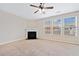 Large living room with fireplace, ceiling fan, and big windows at 4920 Fourth Rail Ln, Cumming, GA 30040
