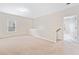 A bright and spacious loft area with neutral walls and carpet flooring, filled with natural light from a large window at 4920 Fourth Rail Ln, Cumming, GA 30040
