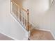 Carpeted stairway with wood banister and white risers at 4920 Fourth Rail Ln, Cumming, GA 30040