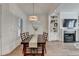 Bright dining area with a long wooden table, a chandelier, and an open view to the living room and fireplace at 1006 Fendley St, Woodstock, GA 30188