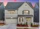 Charming two-story home with gray siding, well-manicured landscaping and a two car garage at 1006 Fendley St, Woodstock, GA 30188