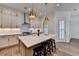 Well-lit kitchen includes a central island with bar stools and pendant lights, adding a cozy touch at 1006 Fendley St, Woodstock, GA 30188