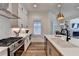 Modern kitchen boasts stainless steel appliances, white cabinetry, and a large island with quartz countertops at 1006 Fendley St, Woodstock, GA 30188