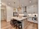 Modern kitchen features stainless steel appliances, white cabinetry, pendant lighting, and a central island with seating at 1006 Fendley St, Woodstock, GA 30188