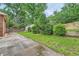 Backyard featuring patio, lawn, mature trees, and a storage shed, plus a tiered retaining wall at 1523 Pangborn Station Dr, Decatur, GA 30033
