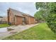 Charming brick home featuring mature trees, side yard and paved driveway at 1523 Pangborn Station Dr, Decatur, GA 30033