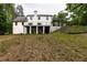 Expansive backyard view of the white brick two-story house with covered patio and stairs at 4 Bentley Trace Mnr, Atlanta, GA 30327