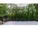 The backyard deck features a dark metal rail overlooking green foliage and trees at 4 Bentley Trace Mnr, Atlanta, GA 30327