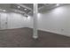 Unfinished basement space featuring modern lighting, neutral walls and flooring, and a support column at 4 Bentley Trace Mnr, Atlanta, GA 30327