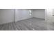 Basement area with gray wood-look tile flooring, bright white walls, and natural light from a window at 4 Bentley Trace Mnr, Atlanta, GA 30327