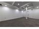 Unfinished basement space featuring modern lighting, neutral walls and flooring, with a support column at 4 Bentley Trace Mnr, Atlanta, GA 30327