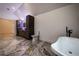 Spacious bathroom with marble tiled floors, soaking tub, vanity, and toilet at 4 Bentley Trace Mnr, Atlanta, GA 30327