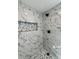 Close-up of luxurious walk-in shower with marble tile and mosaic accent at 4 Bentley Trace Mnr, Atlanta, GA 30327
