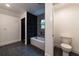 Bright bathroom features a tub with dark grey tiles, walk in shower and toilet at 4 Bentley Trace Mnr, Atlanta, GA 30327