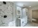 Luxurious bathroom features marble tile, glass shower, modern vanity, and illuminated mirror at 4 Bentley Trace Mnr, Atlanta, GA 30327