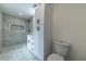 Modern bathroom featuring marble tile, glass enclosed shower, and sleek white vanity with dark hardware at 4 Bentley Trace Mnr, Atlanta, GA 30327