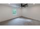 A bright, carpeted bedroom features a modern ceiling fan and window with wooded views at 4 Bentley Trace Mnr, Atlanta, GA 30327
