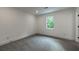 A carpeted bedroom features a window with wooded views and modern baseboard trim at 4 Bentley Trace Mnr, Atlanta, GA 30327