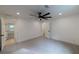 A spacious bedroom featuring plush carpeting, ceiling fan, and multiple access doors at 4 Bentley Trace Mnr, Atlanta, GA 30327