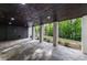 This covered patio features a dark wood ceiling, brick pillars, and a green backyard at 4 Bentley Trace Mnr, Atlanta, GA 30327