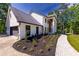 Exterior shot of beautiful white brick home showing the attached garage and expertly landscaped grounds at 4 Bentley Trace Mnr, Atlanta, GA 30327