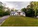 Stunning two-story home with a manicured lawn and elegant, column-lined entryway, surrounded by lush trees at 4 Bentley Trace Mnr, Atlanta, GA 30327