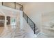 Bright foyer showcasing stairs with modern railings and elegant flooring leading to a spacious kitchen at 4 Bentley Trace Mnr, Atlanta, GA 30327
