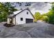 Exterior view of detached garage with black garage door, landscaping, and paved driveway at 4 Bentley Trace Mnr, Atlanta, GA 30327