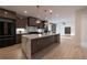 Modern kitchen featuring a large island, stylish cabinetry, and stainless steel appliances, open to living area at 4 Bentley Trace Mnr, Atlanta, GA 30327