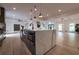 Island kitchen features stainless steel sink and microwave, marble countertop and pendant lighting at 4 Bentley Trace Mnr, Atlanta, GA 30327