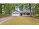 Well-kept single-story home with attached garage, appealing front porch, and lush green lawn surrounded by mature trees at 4771 Pinefield Nw Dr, Acworth, GA 30102