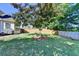 A landscaped backyard with green lawn, bordered by mature trees and a wooden fence create a peaceful outdoor setting at 1550 Misty Valley Dr, Lawrenceville, GA 30045
