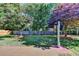 Large backyard features a patio, lush lawn, mature trees, wooden fence, and bird feeding station at 1550 Misty Valley Dr, Lawrenceville, GA 30045