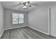 Comfortable bedroom with a ceiling fan, a window, and wood-look floors at 1550 Misty Valley Dr, Lawrenceville, GA 30045