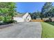 Long concrete driveway to the side of a house with attached garage and well-maintained lawn at 1550 Misty Valley Dr, Lawrenceville, GA 30045