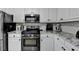 Kitchen with stainless steel appliances and white cabinets with dark hardware at 1550 Misty Valley Dr, Lawrenceville, GA 30045