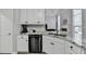 Kitchen with stainless steel dishwasher and white cabinets, open to living room at 1550 Misty Valley Dr, Lawrenceville, GA 30045