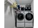 Laundry room showcasing a modern, front-load washer and dryer and shelving at 1550 Misty Valley Dr, Lawrenceville, GA 30045