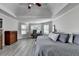 Spacious main bedroom featuring a ceiling fan, ensuite office space, and wood-look floors at 1550 Misty Valley Dr, Lawrenceville, GA 30045