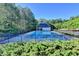 Community outdoor swimming pool with a pool house, surrounded by mature trees and greenery at 1550 Misty Valley Dr, Lawrenceville, GA 30045