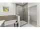Contemporary bathroom showcasing glass-enclosed shower, soaking tub, and entrance to the walk-in closet at 216 Creek View Pl, Canton, GA 30114