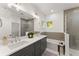 Modern bathroom featuring double sinks, stylish lighting, and glass-enclosed shower and tub combination at 216 Creek View Pl, Canton, GA 30114