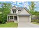 Charming two-story home featuring a covered porch, attached garage, and professionally landscaped yard at 216 Creek View Pl, Canton, GA 30114