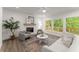 Inviting living room featuring large windows, a cozy fireplace, and neutral décor at 216 Creek View Pl, Canton, GA 30114