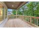 Inviting covered porch with wooden railings, offering serene views of the surrounding greenery at 216 Creek View Pl, Canton, GA 30114