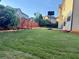 Expansive backyard featuring a well-maintained lawn, basketball hoop, and garden area with a wooden fence at 3670 Kissell Dr, Cumming, GA 30041