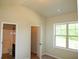 Bright bedroom with vaulted ceilings and ensuite bathroom access, offering comfort and privacy at 3670 Kissell Dr, Cumming, GA 30041